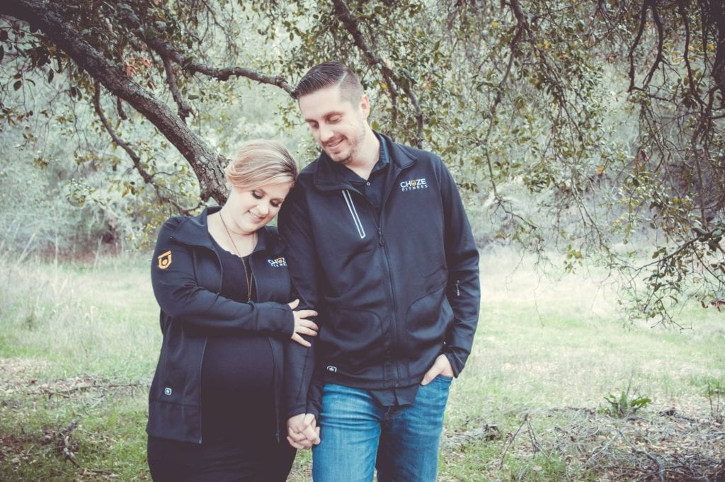 Team Members, Nathan and Julia Muzquiz, wearing their Chuze Fitness jackets for their maternity photos.