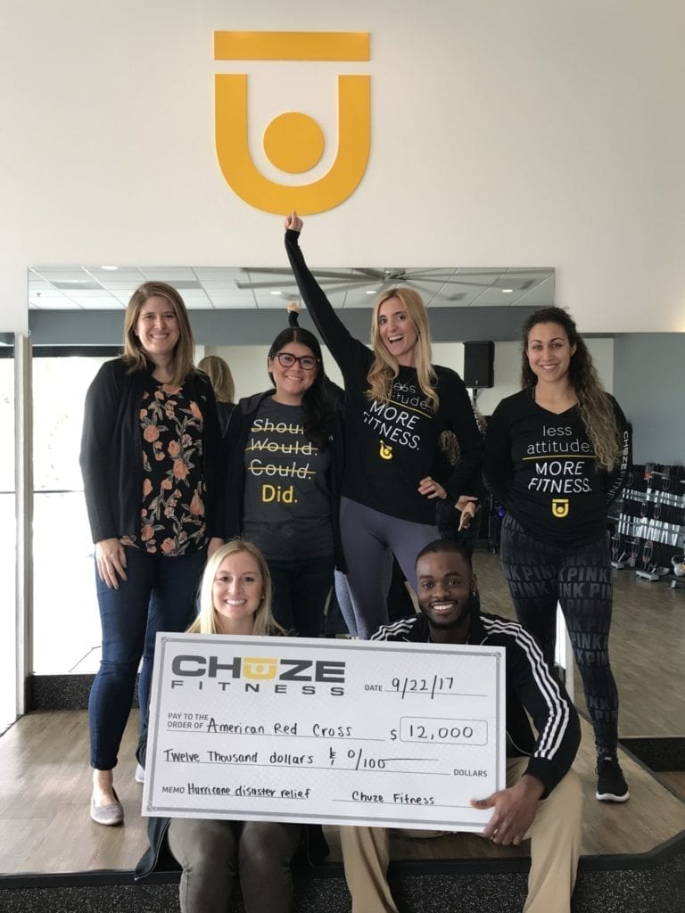 Chuze Fitness team members with donation check to disaster relief fund