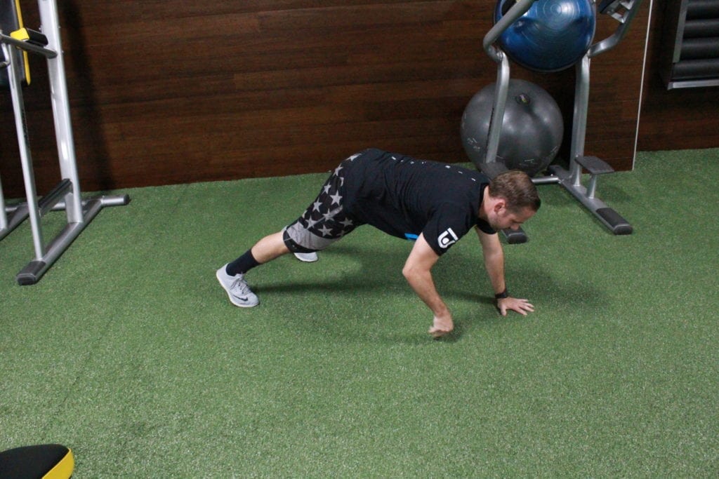 Man demonstrating the bodyweight hiit workout inch worm 
